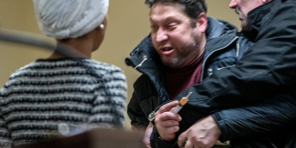 Uomo spruzza liquido su Ilhan Omar durante town hall a Minneapolis
