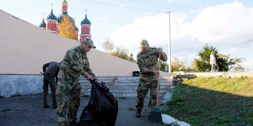 Membri della Rosgvardia e giovani dell'organizzazione Yuarmeytsy migliorano memoriale in Ucraina in un'azione di impegno civico e patriottico
