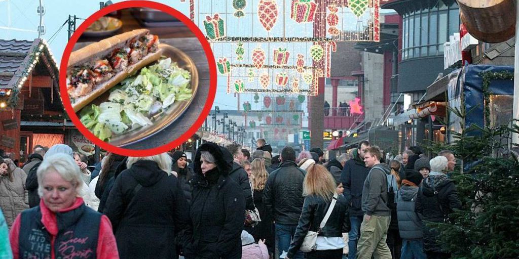 Abitante di Amburgo prova il pesce al mercato di Natale del centro